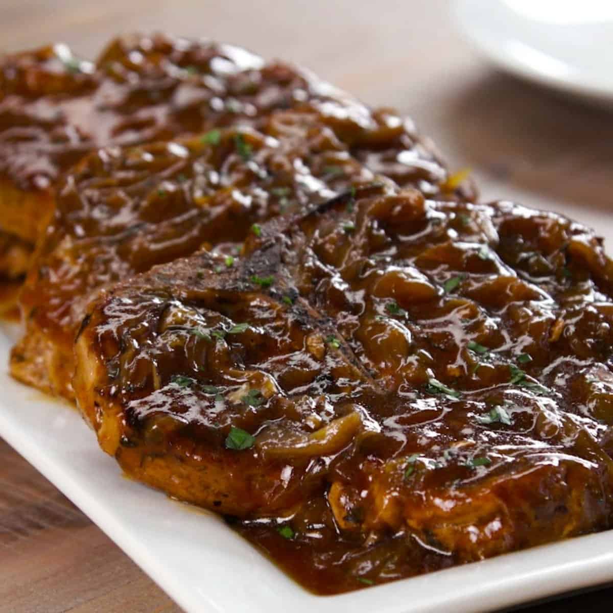 Tray of slow cooked pork chops with onion gravy.