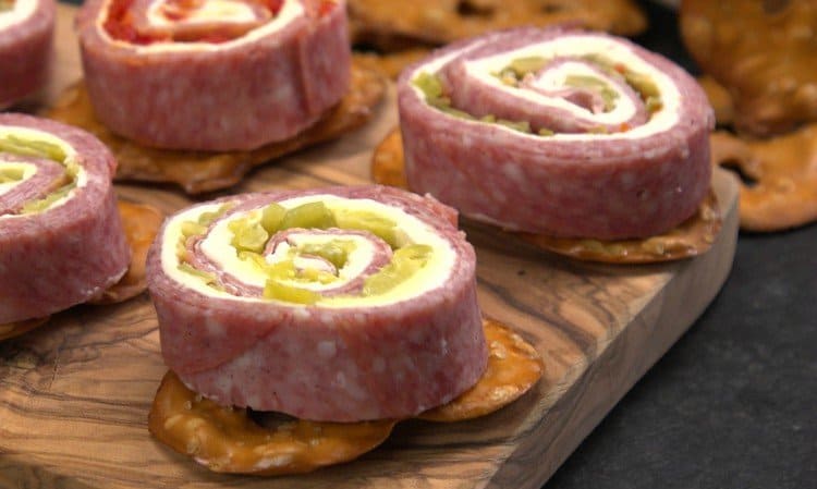 Close-up shot of Cream Cheese Salami Roll Ups on board.