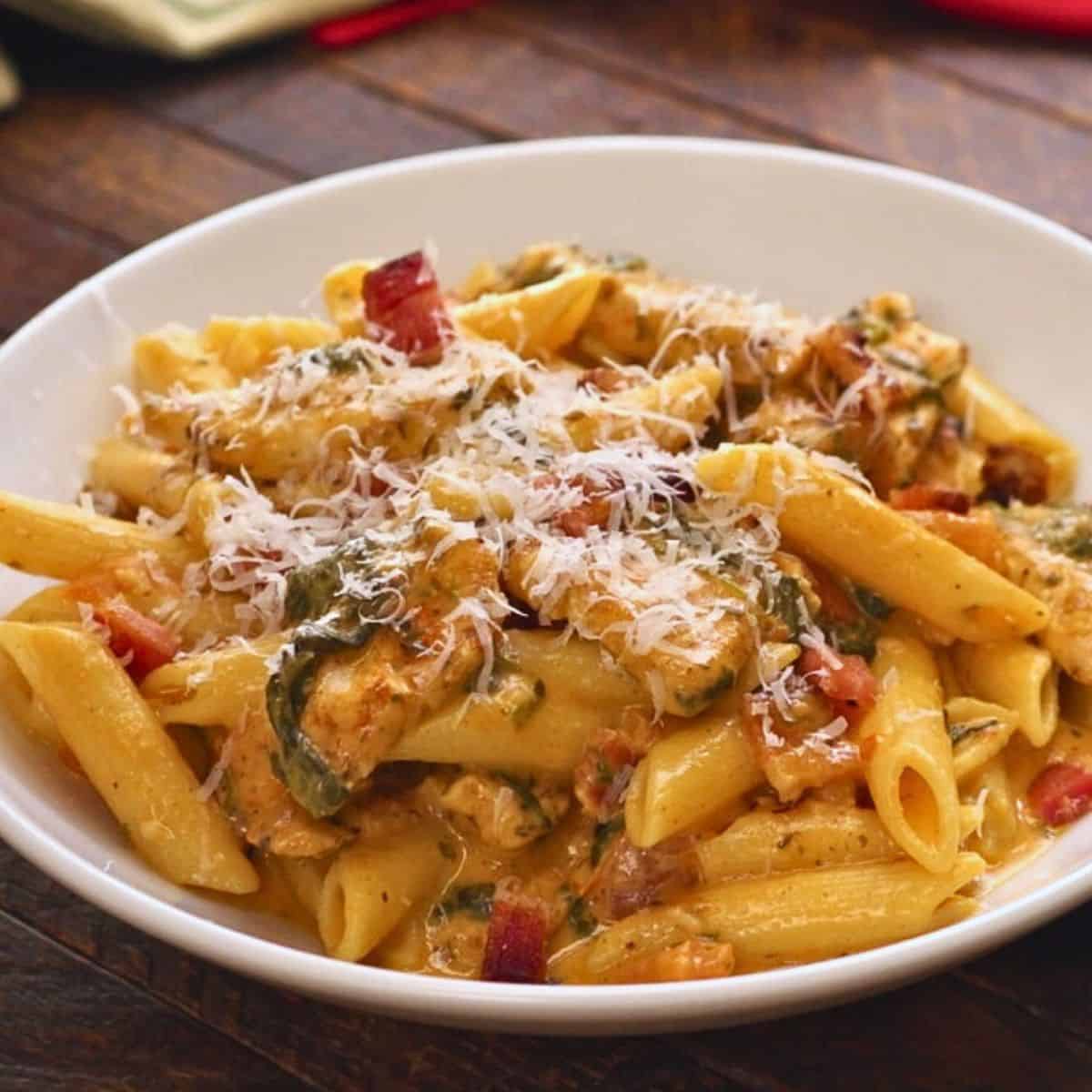 Creamy chicken and bacon pasta in bowl.