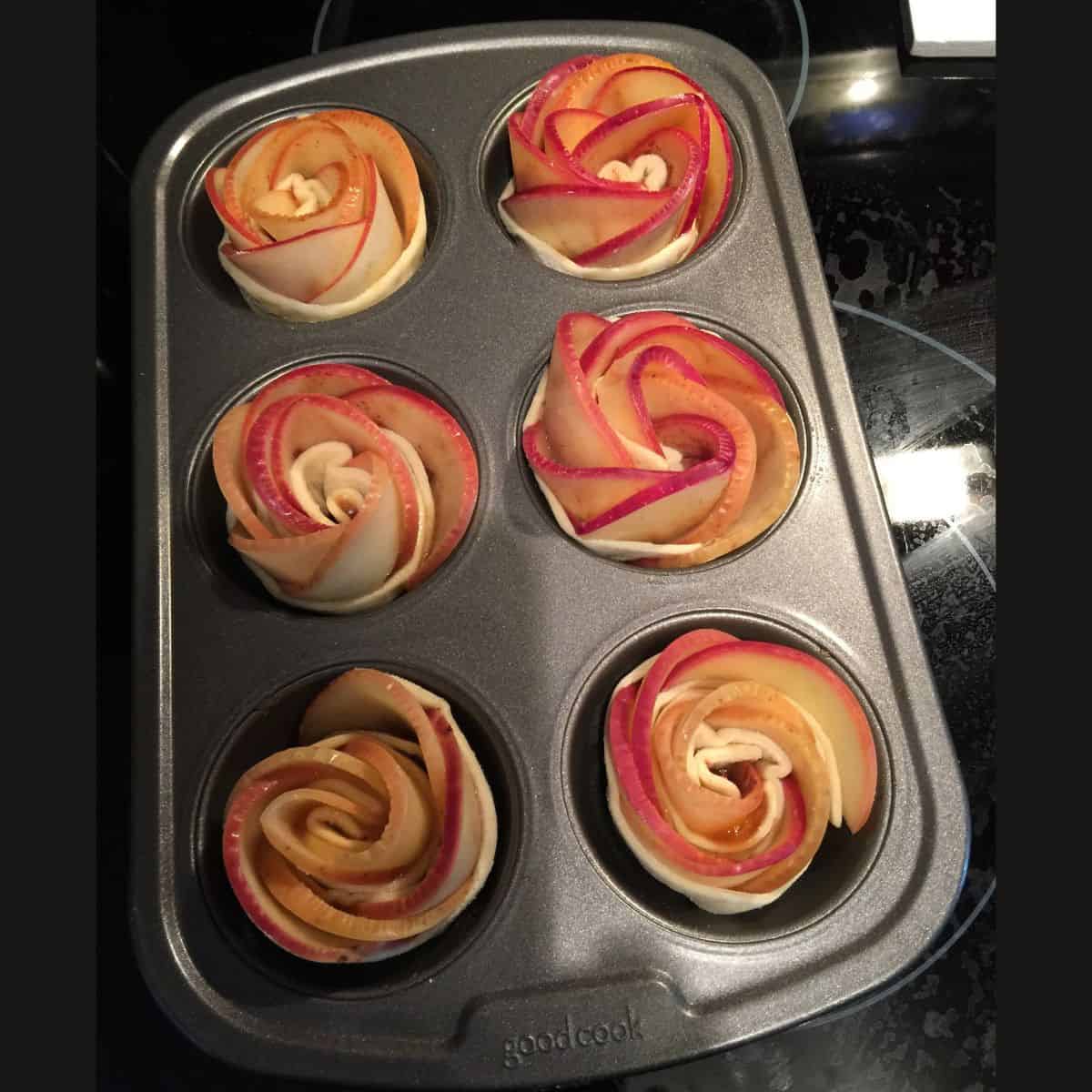Apple roses in muffin tin before going into oven.