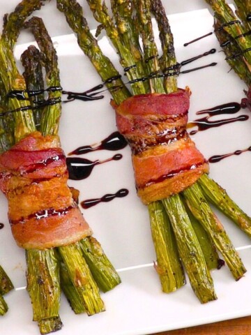 Bacon Wrapped Asparagus on platter with honey balsamic glaze.
