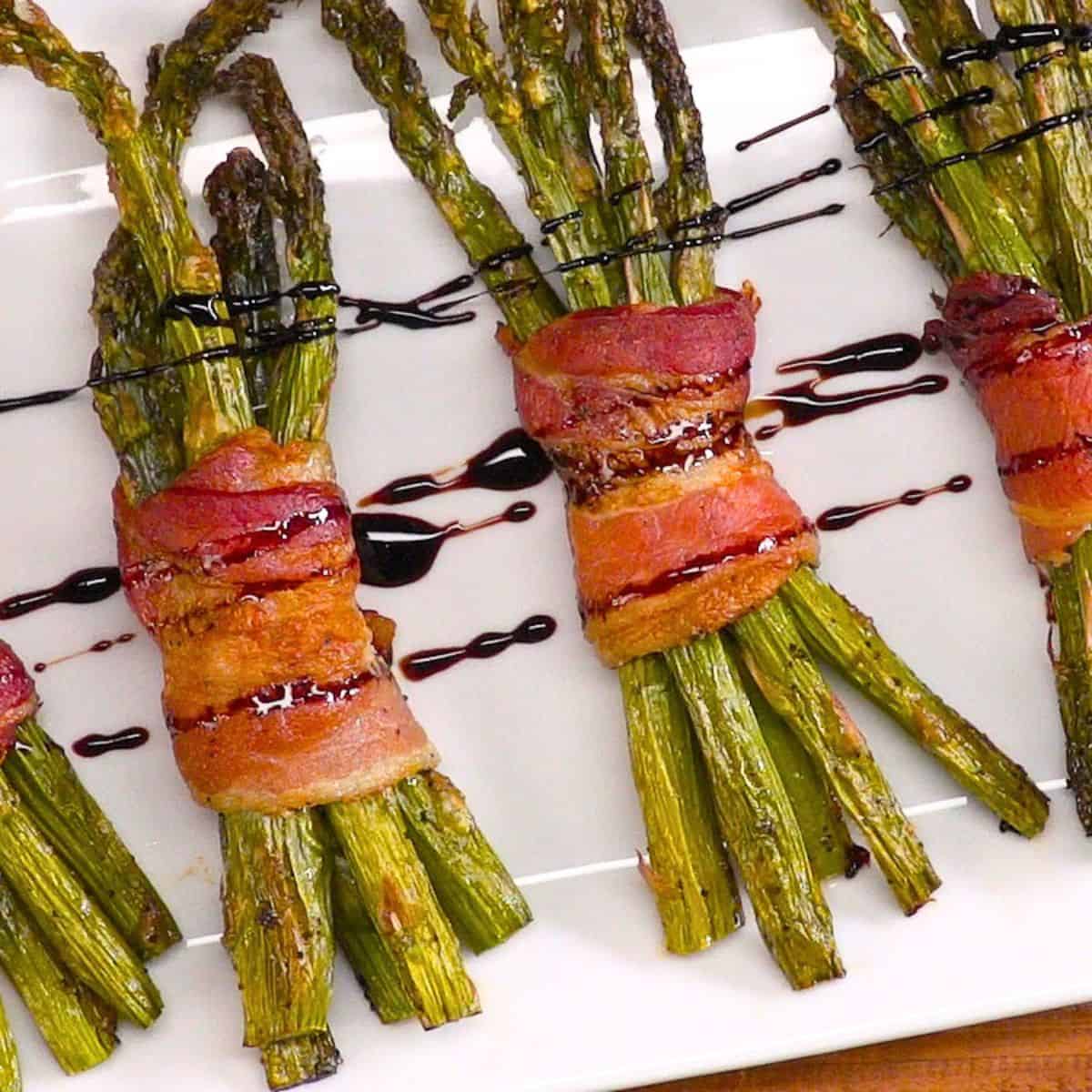Bacon Wrapped Asparagus on platter with honey balsamic glaze.