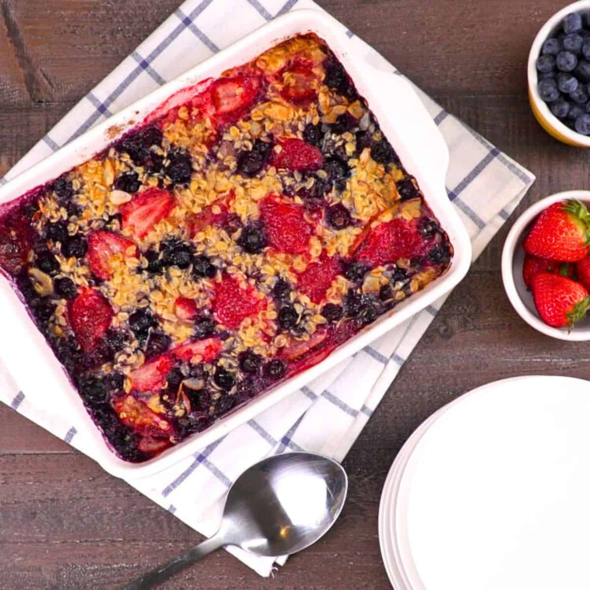 Top down shot of baked oatmeal in casserole showing bueberries and strawberries.