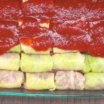 Cabbage rolls with sauce in casserole dish.