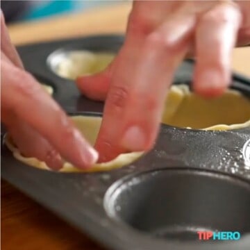 Placing crust in muffin tin.