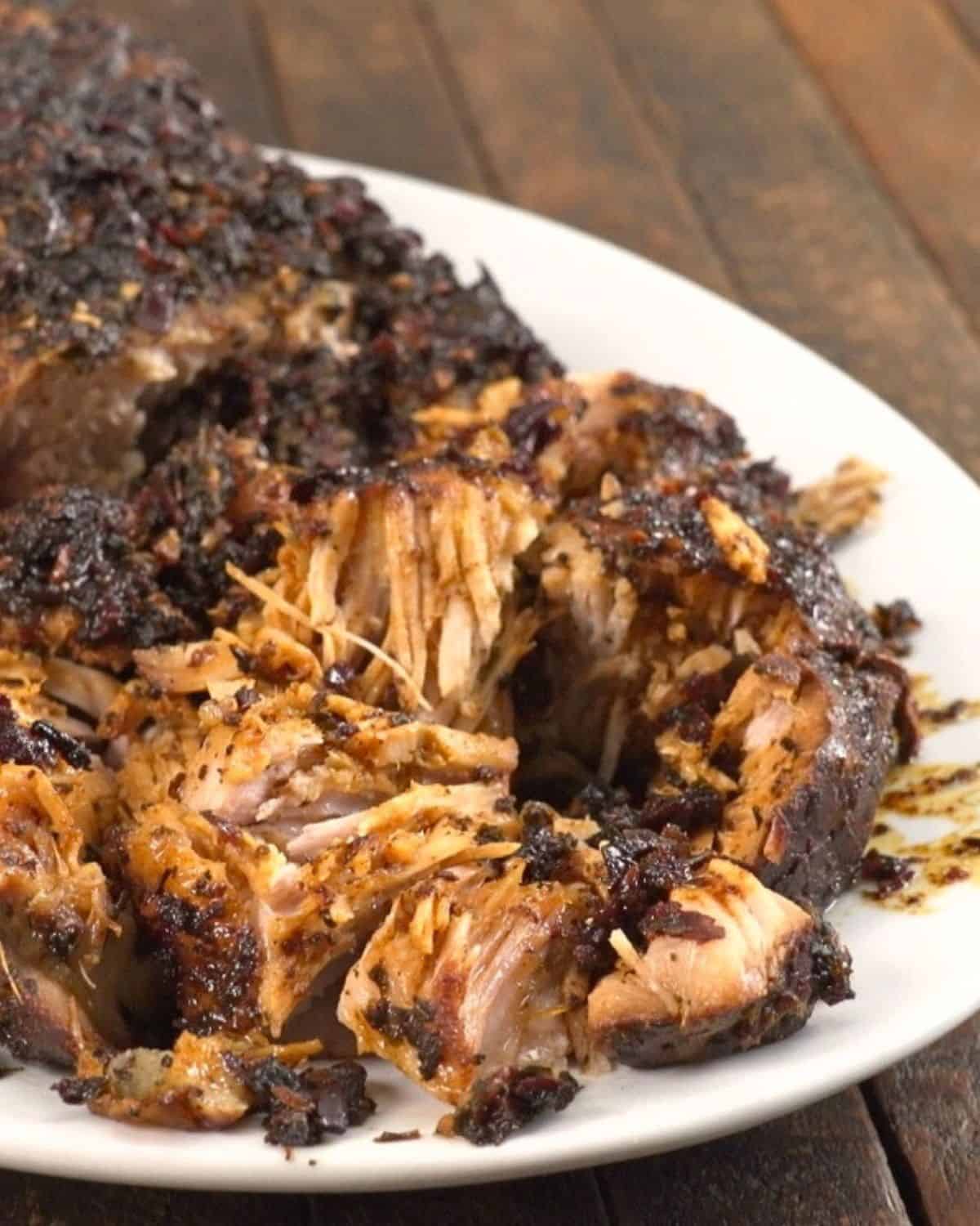 Slow cooker honey pork roast on platter with sauce.