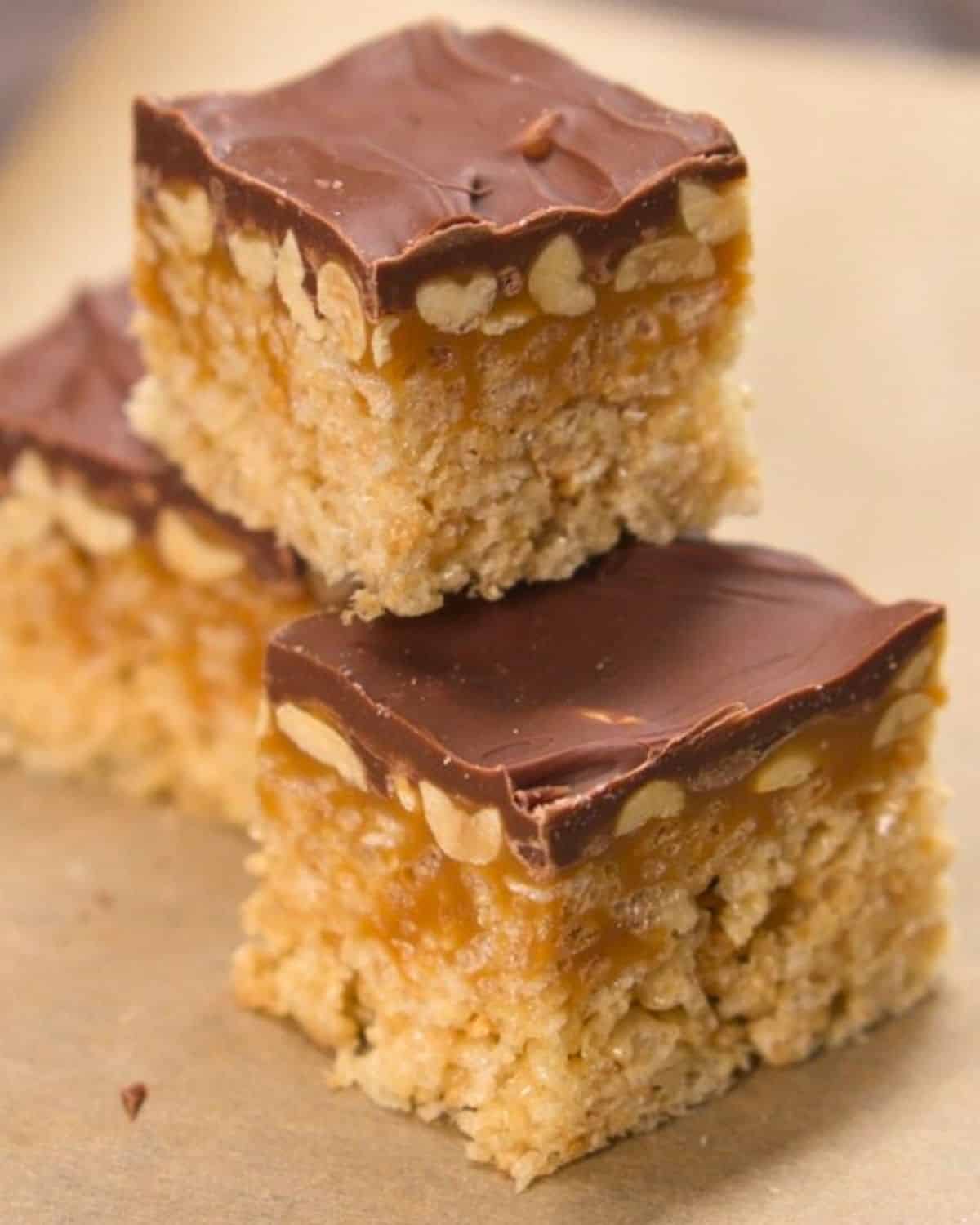 Close up shot of Snickers Inspired rice krispies treat on wax paper.
