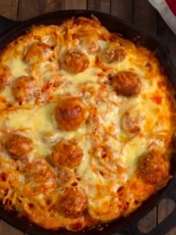 Looking down on Baked Spaghetti & Meatballs in black skillet.