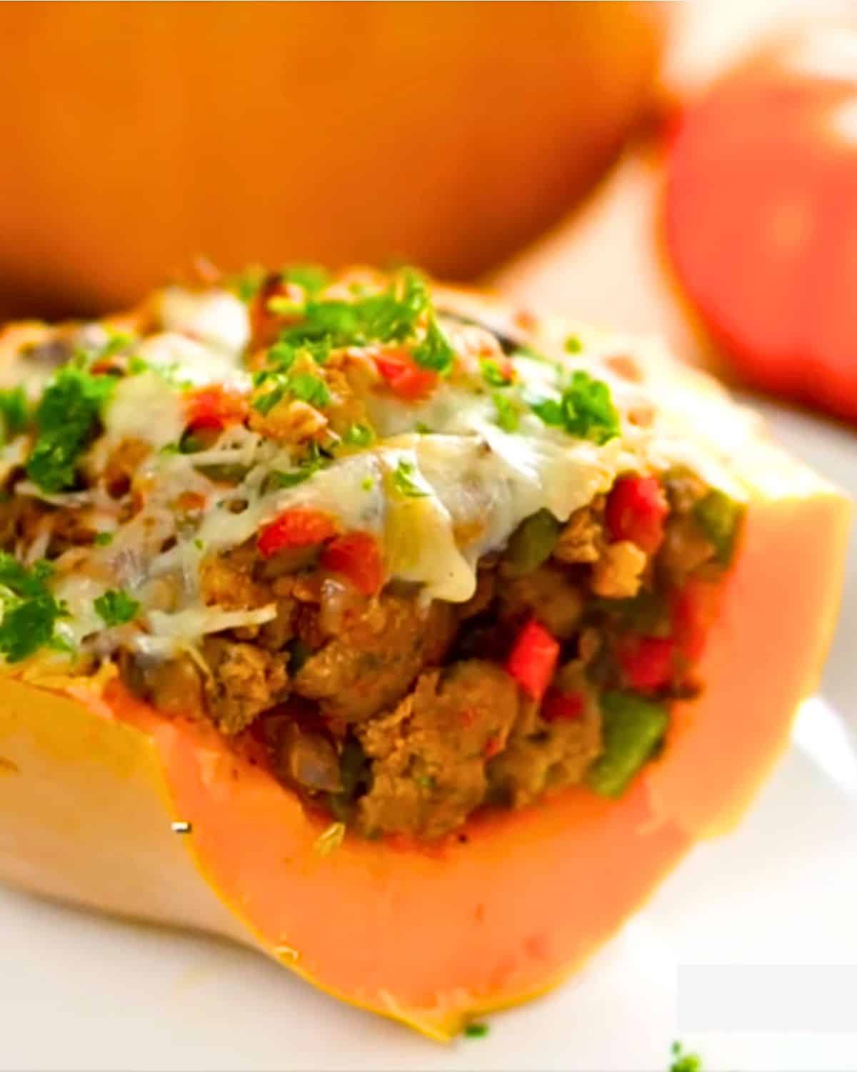 close up of stuffed butternut squash with sausage and peppers.